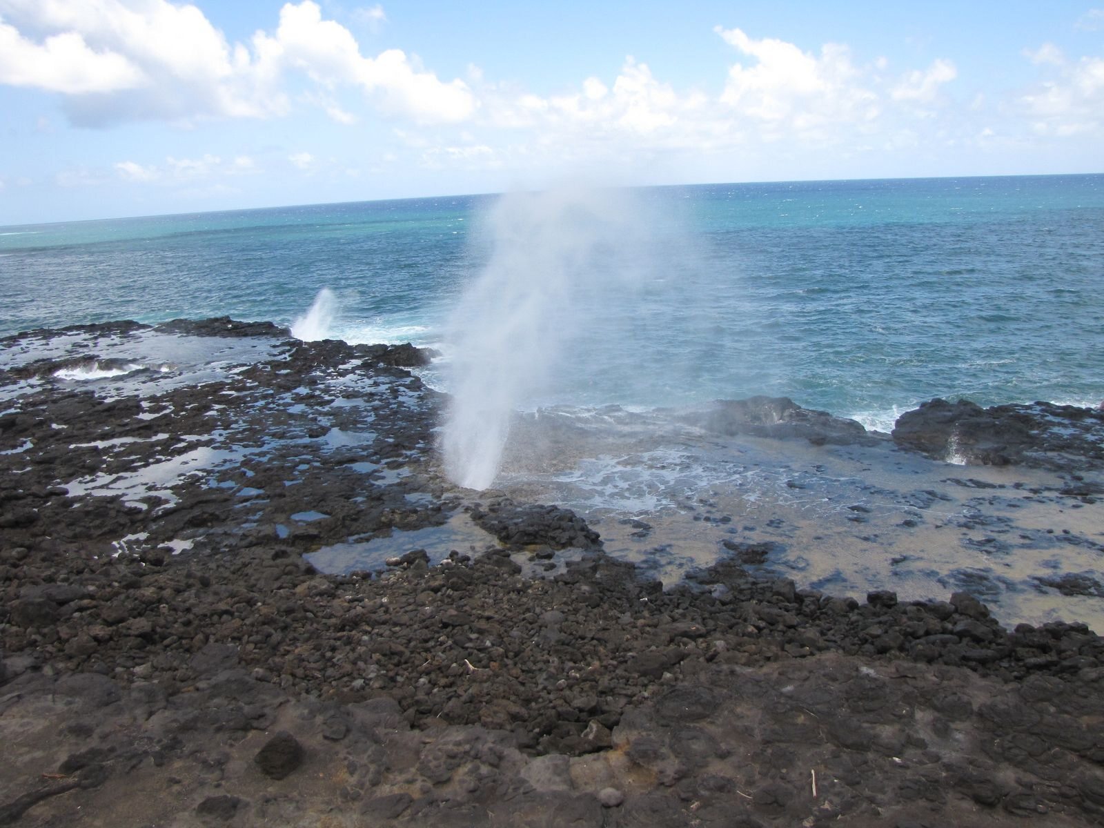 Ocean spray rising from rocks on the Kauai coast