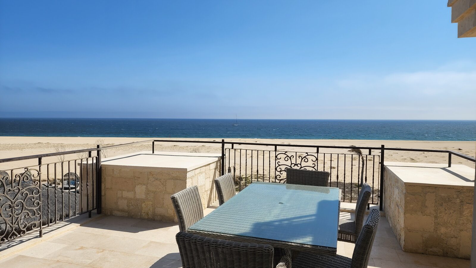 Ocean-view terrace with table and railing on a clear Cabo day