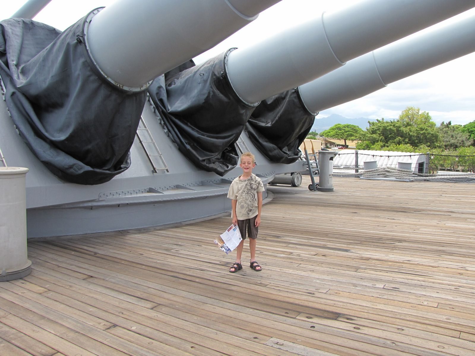 One of Roger's sons beneath the large guns on a battleship deck at Pearl Harbor