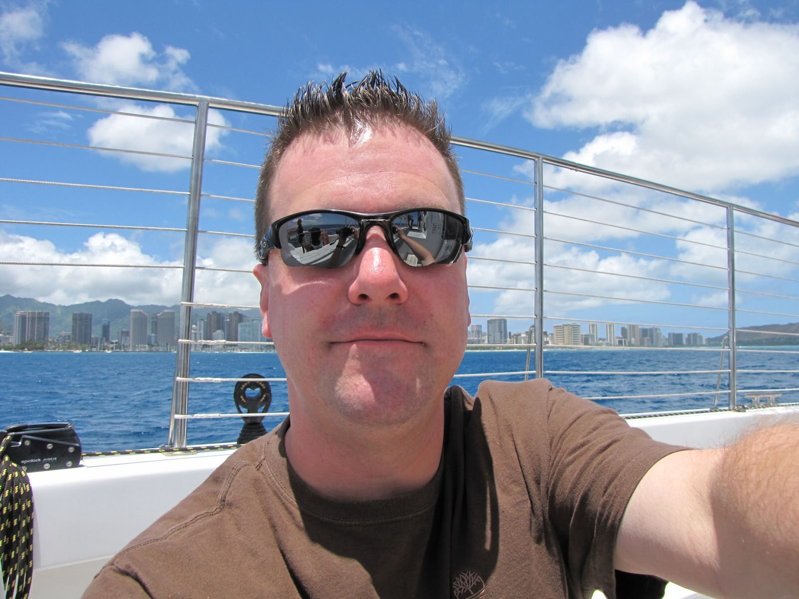 Roger aboard a boat with the Honolulu shoreline behind him