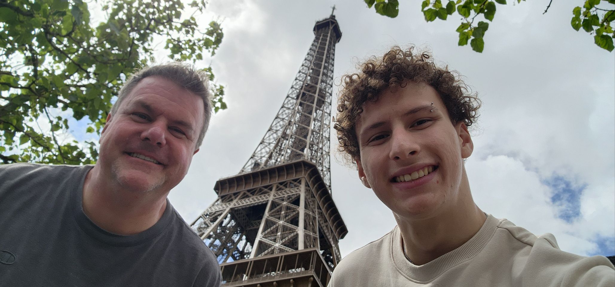 Roger and a son smiling near the Eiffel Tower