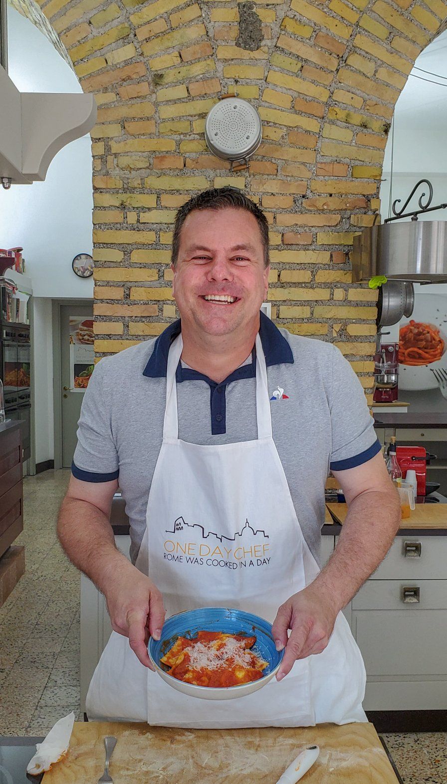 Roger's son holding a fresh pasta dish after a cooking class