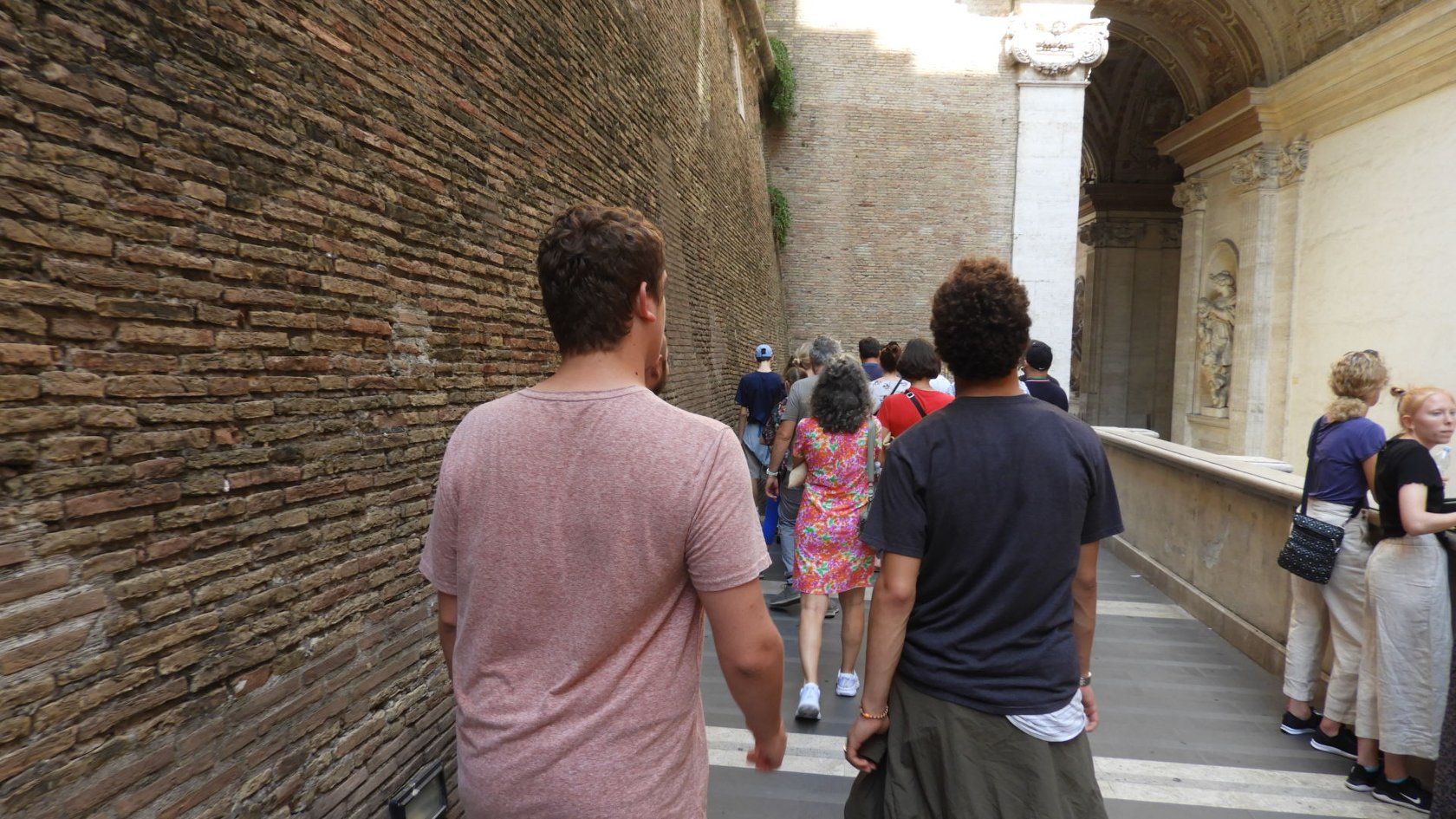 Two of Roger's sons walking through a stone corridor in Vatican City