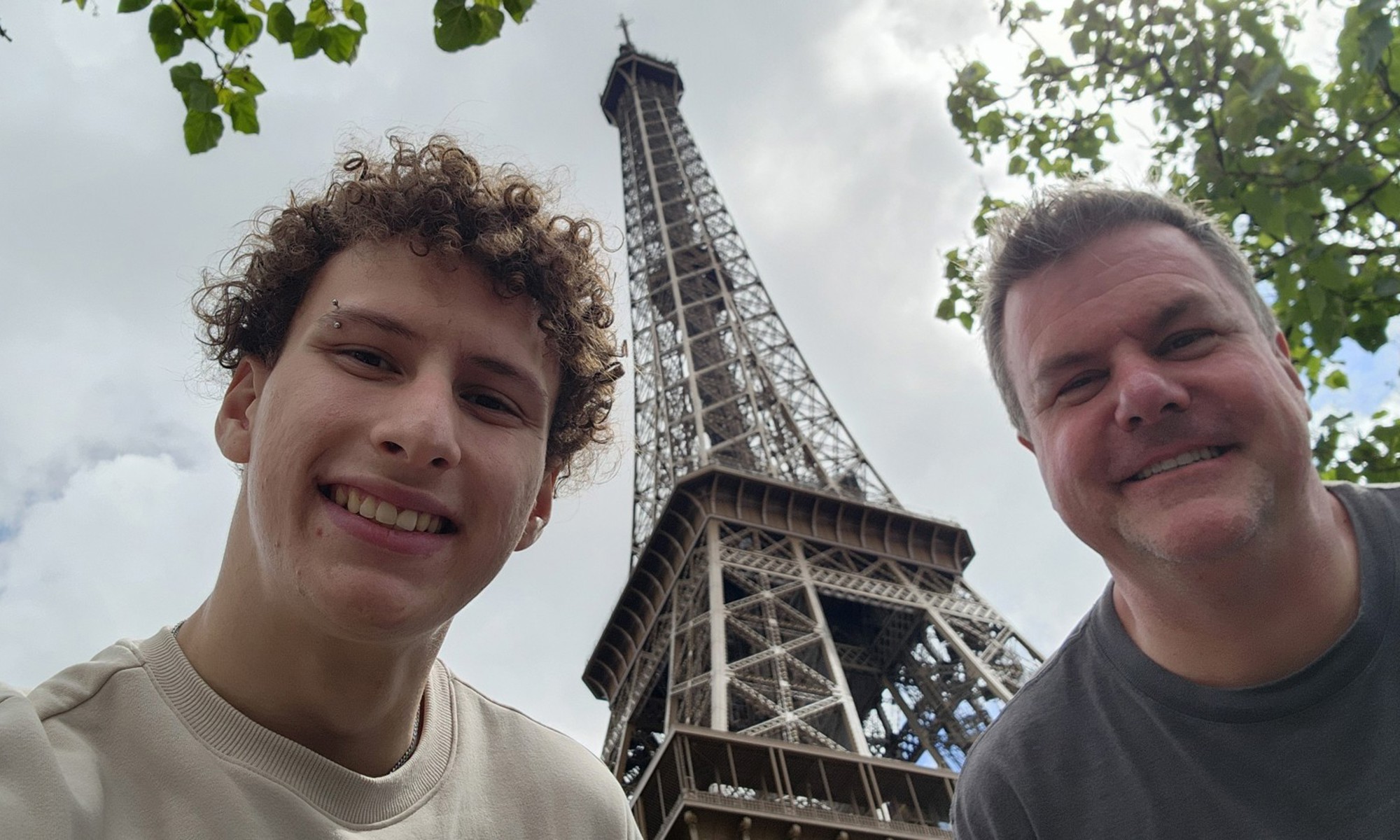 Roger and Faris smiling in front of the Eiffel Tower in Paris
